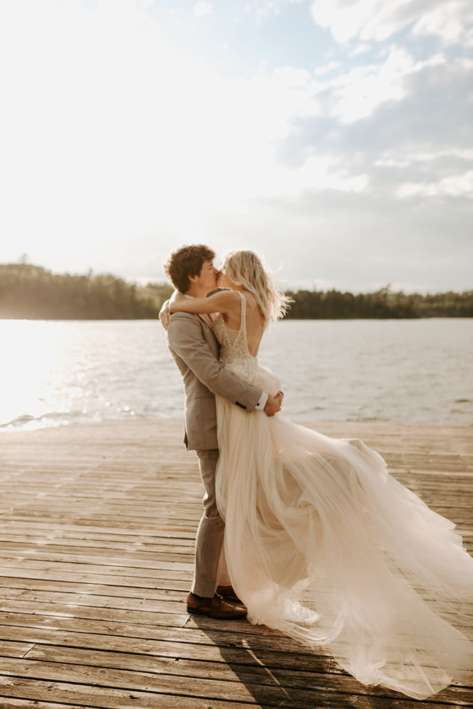 Bride and groom on dock at sunset during their wedding in Lake of the Woods, Kenora, Ontario