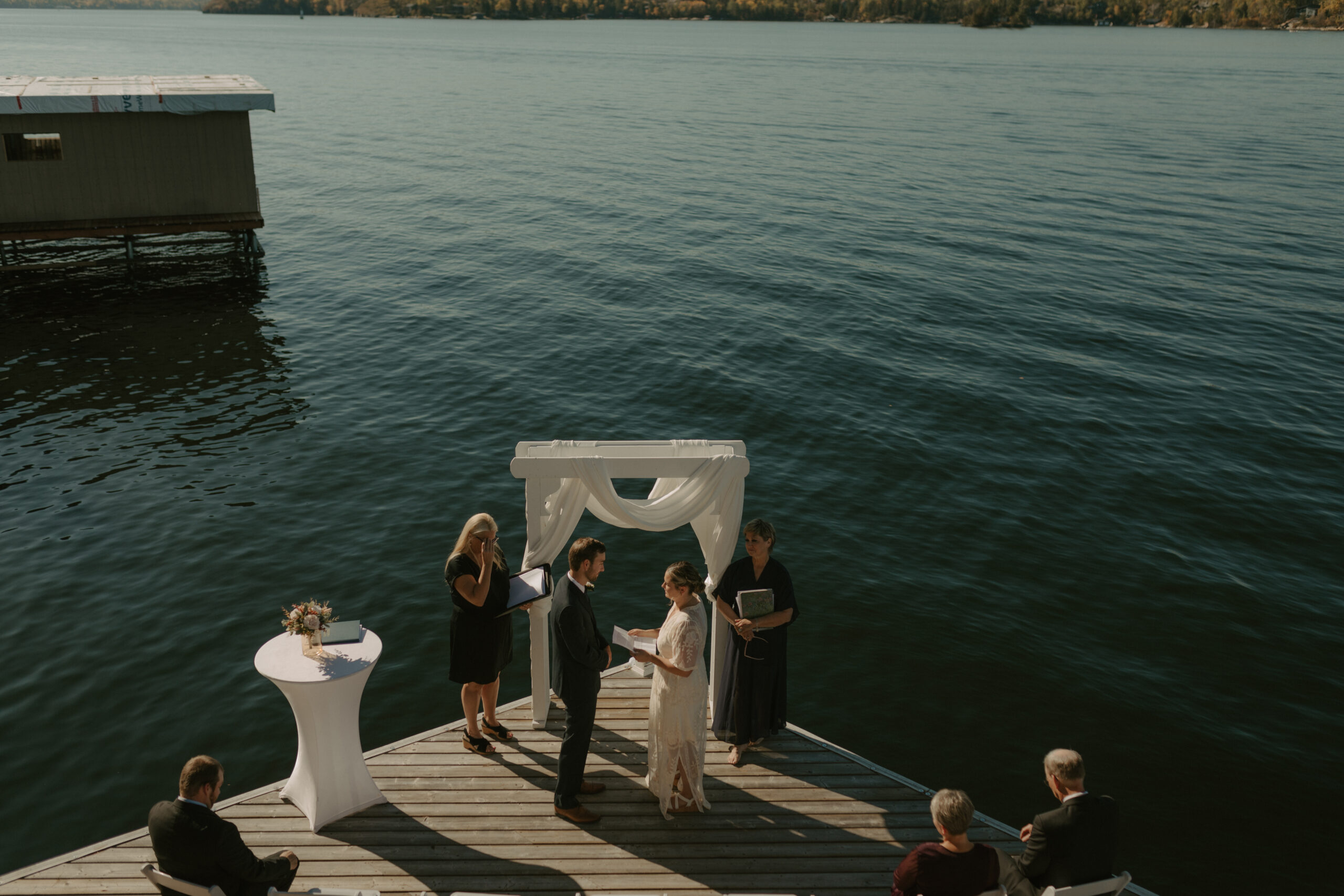 Bride and groom exchanging vows on their dock at their cabin in lake of the woods Kenora, Ontario